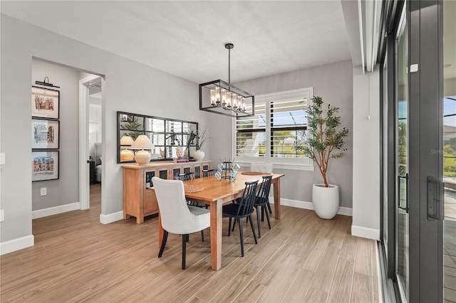 16226 Hidden Oak Loop, Bradenton, FL 34211 - dining area with light wood-style floors, a chandelier, and baseboards