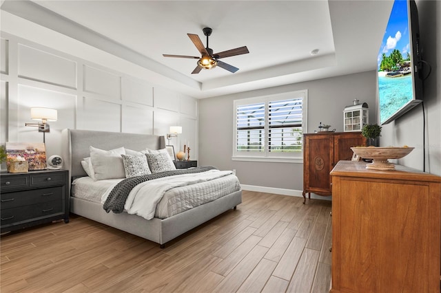 16226 Hidden Oak Loop, Bradenton, FL 34211 - bedroom with a tray ceiling, baseboards, light wood-type flooring, and ceiling fan