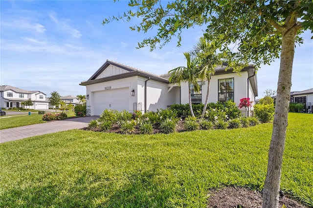 16226 Hidden Oak Loop, Bradenton, FL 34211 - ranch-style house featuring driveway, a front lawn, an attached garage, and stucco siding