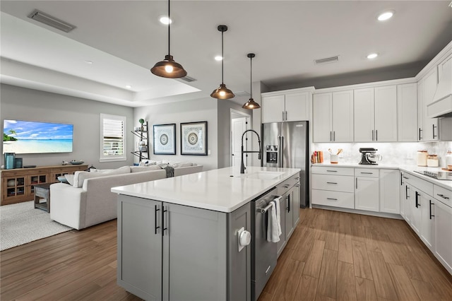 16226 Hidden Oak Loop, Bradenton, FL 34211 - kitchen with a sink, appliances with stainless steel finishes, wood finished floors, light countertops, and a kitchen island with sink