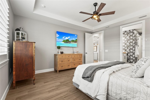 16226 Hidden Oak Loop, Bradenton, FL 34211 - bedroom with baseboards, light wood-type flooring, a raised ceiling, and ceiling fan