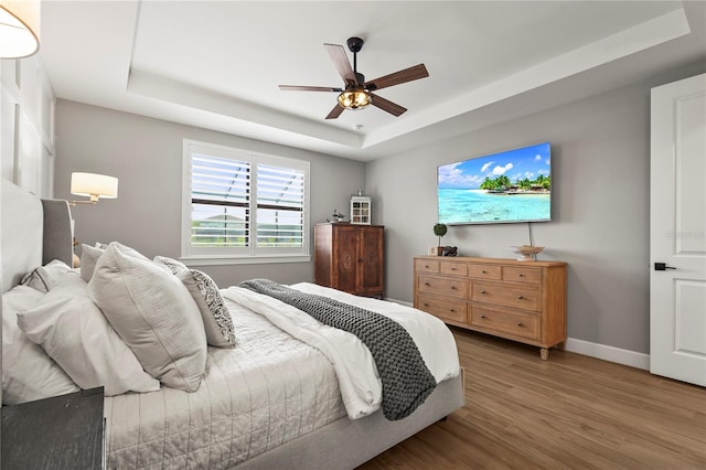 16226 Hidden Oak Loop, Bradenton, FL 34211 - bedroom with a tray ceiling, wood finished floors, baseboards, and ceiling fan