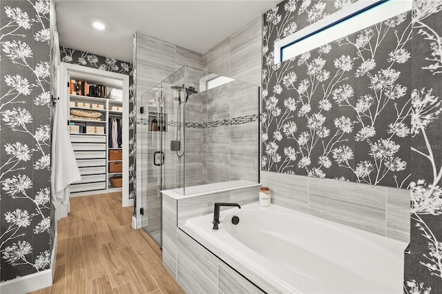 16226 Hidden Oak Loop, Bradenton, FL 34211 - full bathroom featuring a garden tub, a shower stall, a spacious closet, and wood finished floors