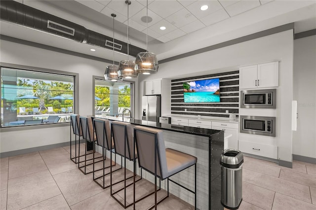 16226 Hidden Oak Loop, Bradenton, FL 34211 - kitchen with stainless steel appliances, baseboards, a breakfast bar, white cabinetry, and recessed lighting
