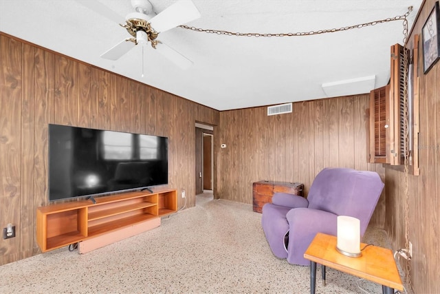 6628 Auburn Ave, Bradenton, FL 34207 - living room featuring ceiling fan, wooden walls, and speckled floor