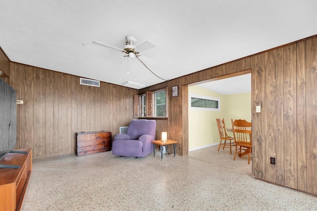 6628 Auburn Ave, Bradenton, FL 34207 - sitting room featuring wood walls, a ceiling fan, speckle patterned floor, and baseboards