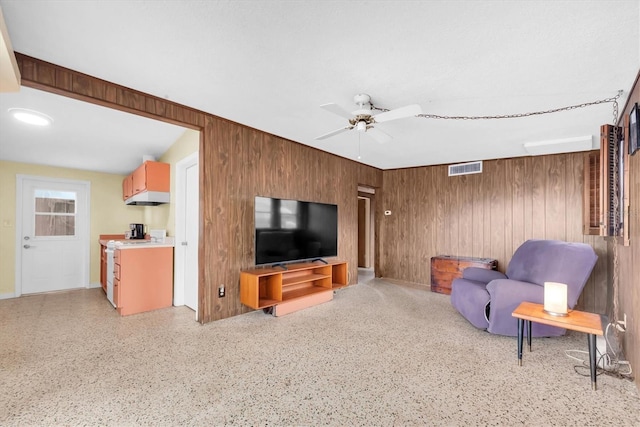 6628 Auburn Ave, Bradenton, FL 34207 - living room with wood walls, ceiling fan, and dark aggregate flooring
