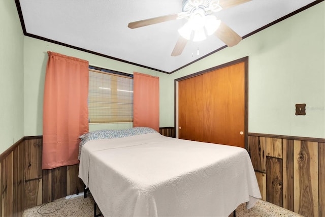 6628 Auburn Ave, Bradenton, FL 34207 - bedroom featuring a wainscoted wall, speckled floor, crown molding, a ceiling fan, and a closet