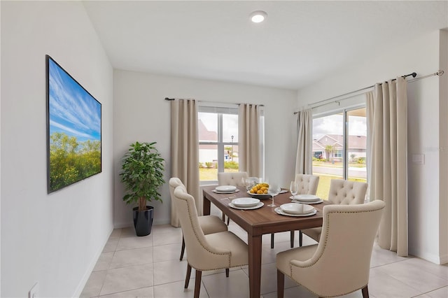 dining room with healthy amount of natural light, light tile patterned floors, and baseboards