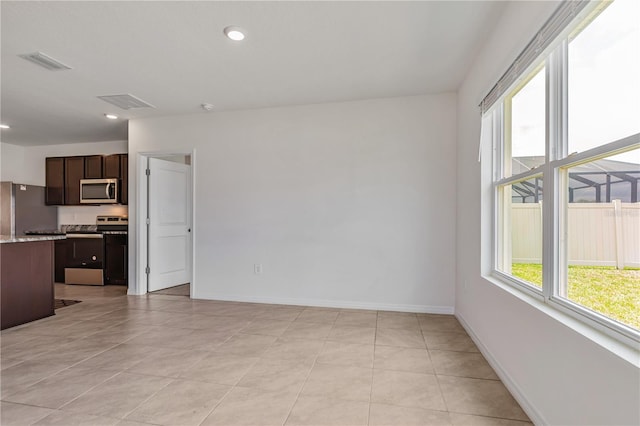 unfurnished living room with baseboards, light tile patterned flooring, and recessed lighting