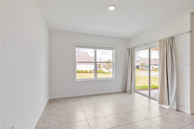 unfurnished room with baseboards and light tile patterned flooring