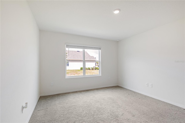 empty room featuring carpet flooring and baseboards