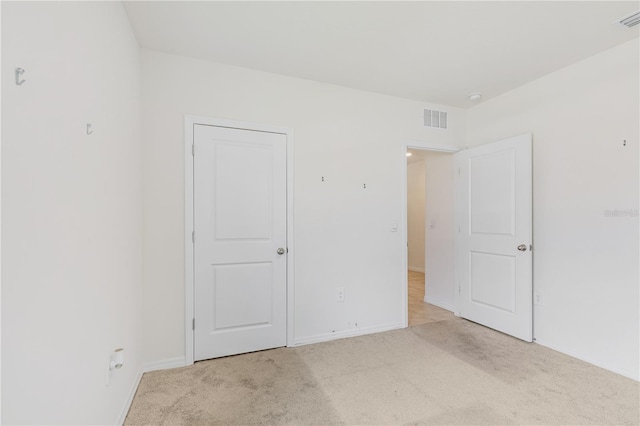 unfurnished bedroom with light carpet and baseboards