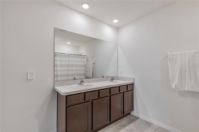bathroom featuring tile patterned flooring, double vanity, baseboards, and a shower with curtain