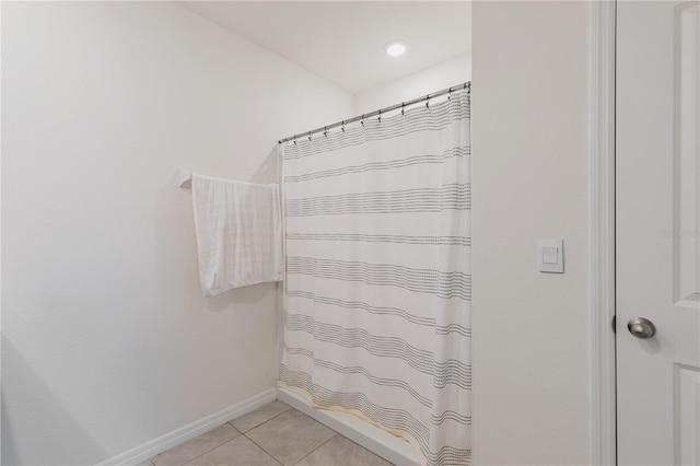 full bathroom featuring tile patterned flooring, curtained shower, and baseboards