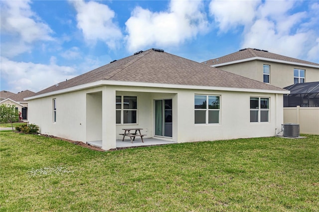 rear view of house with stucco siding, a yard, and a patio