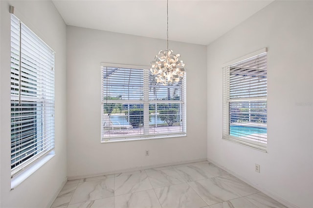 5320 Tide Point Way, Bradenton, FL 34208 - unfurnished dining area with light marble finish floors, healthy amount of natural light, a chandelier, and baseboards