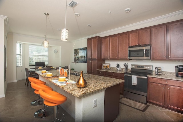 kitchen with appliances with stainless steel finishes, crown molding, dark tile patterned flooring, a sink, and light stone countertops