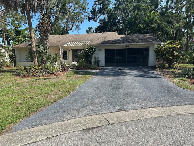 2181 Pine Gardens Trl, Sarasota, FL 34231 - ranch-style house with a garage, asphalt driveway, a front lawn, and stucco siding