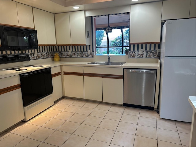 2181 Pine Gardens Trl, Sarasota, FL 34231 - kitchen featuring dishwasher, electric range oven, black microwave, freestanding refrigerator, and a sink