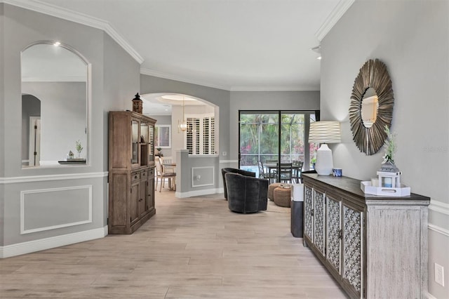 6470 Indigo Bunting Pl, Lakewood Ranch, FL 34202 - hallway with light wood-style flooring, crown molding, arched walkways, and a decorative wall