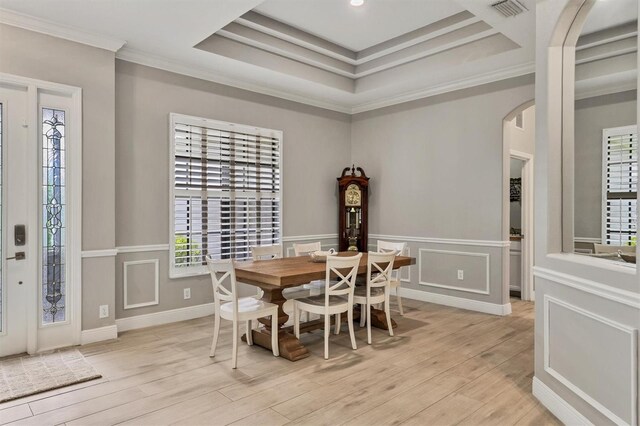 6470 Indigo Bunting Pl, Lakewood Ranch, FL 34202 - dining area with arched walkways, light wood finished floors, ornamental molding, a raised ceiling, and wainscoting