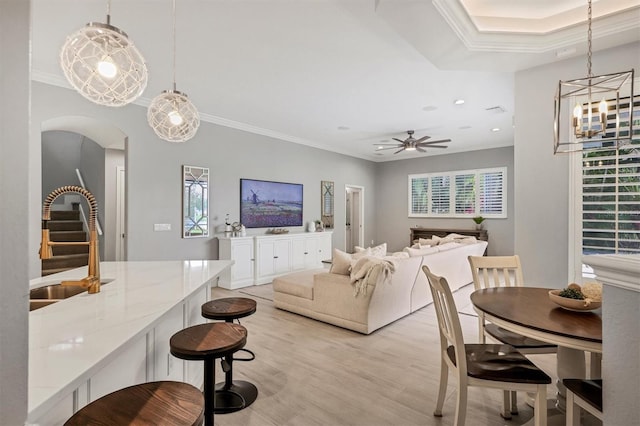 6470 Indigo Bunting Pl, Lakewood Ranch, FL 34202 - living room featuring ornamental molding, ceiling fan, light wood finished floors, arched walkways, and stairs