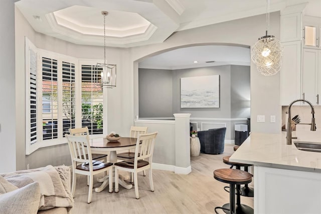 6470 Indigo Bunting Pl, Lakewood Ranch, FL 34202 - dining space featuring light wood-type flooring, arched walkways, crown molding, and a chandelier
