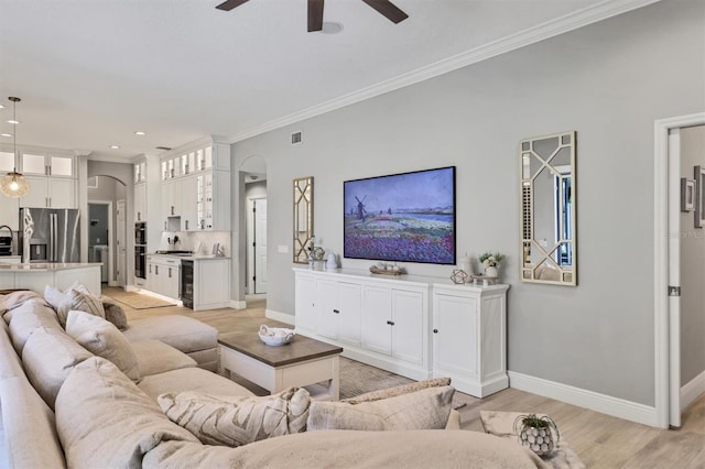 6470 Indigo Bunting Pl, Lakewood Ranch, FL 34202 - living room with arched walkways, ceiling fan, crown molding, light wood-style floors, and recessed lighting