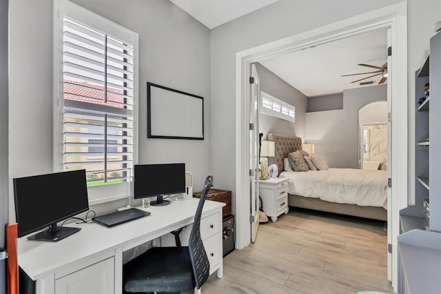 6470 Indigo Bunting Pl, Lakewood Ranch, FL 34202 - bedroom with light wood-style floors, arched walkways, and a desk