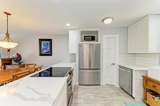 9409 Catalina Dr, Bradenton, FL 34210 - kitchen with appliances with stainless steel finishes, white cabinets, light stone countertops, and recessed lighting
