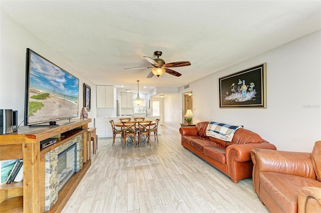 9409 Catalina Dr, Bradenton, FL 34210 - living area featuring light wood-style floors, a ceiling fan, and a textured ceiling