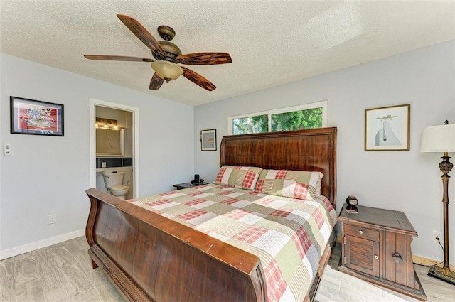 9409 Catalina Dr, Bradenton, FL 34210 - bedroom with a textured ceiling, connected bathroom, baseboards, a ceiling fan, and light wood-style floors