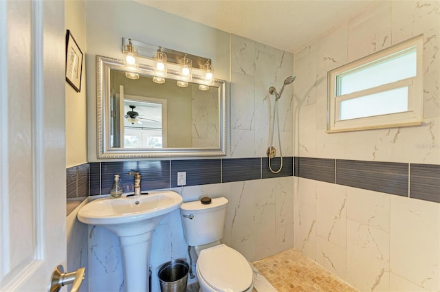 9409 Catalina Dr, Bradenton, FL 34210 - bathroom featuring tiled shower, toilet, plenty of natural light, and tile walls