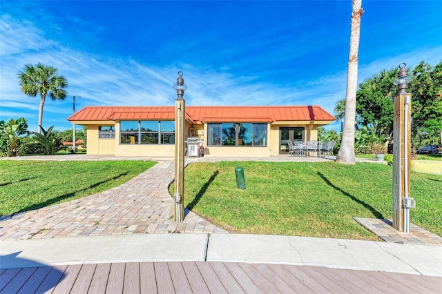 9409 Catalina Dr, Bradenton, FL 34210 - view of front of home featuring a front yard, metal roof, a patio area, a standing seam roof, and stucco siding