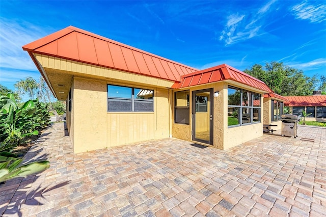 9409 Catalina Dr, Bradenton, FL 34210 - view of front of house featuring stucco siding, a standing seam roof, a patio, and metal roof