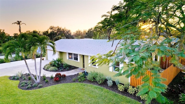 1010 68th St NW, Bradenton, FL 34209 - property exterior at dusk featuring stucco siding, roof with shingles, a garage, and concrete driveway