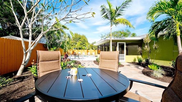 1010 68th St NW, Bradenton, FL 34209 - view of patio featuring outdoor dining space, a sunroom, and a fenced backyard