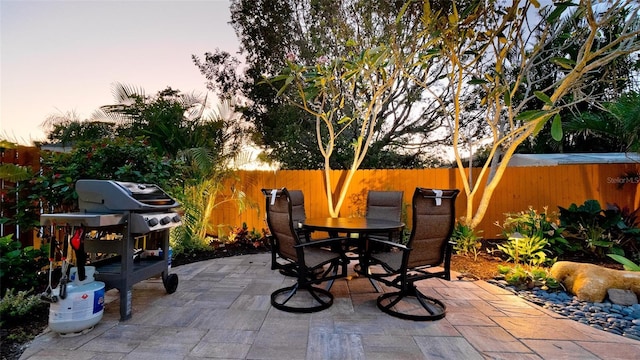 1010 68th St NW, Bradenton, FL 34209 - patio terrace at dusk with outdoor dining space, fence, and area for grilling