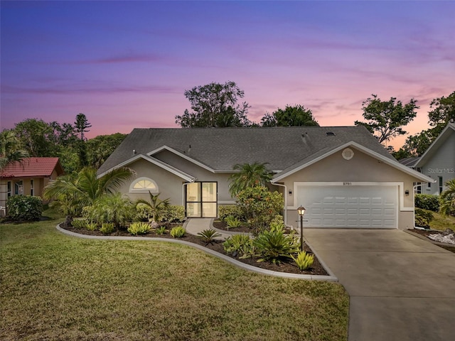 5750 Carriage Dr, Sarasota, FL 34243 - single story home featuring stucco siding, an attached garage, driveway, and a yard