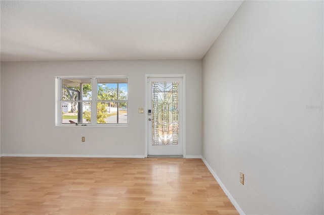 entryway with baseboards and light wood-style flooring