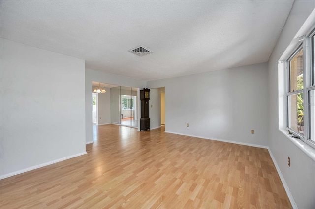 empty room featuring baseboards, a healthy amount of sunlight, and light wood-style floors