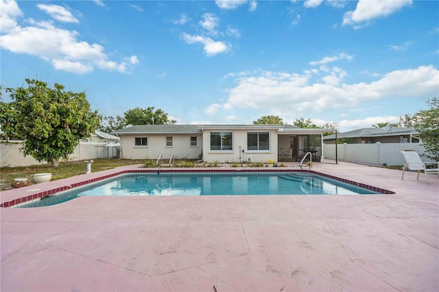 view of swimming pool featuring a patio, a fenced backyard, and a sunroom