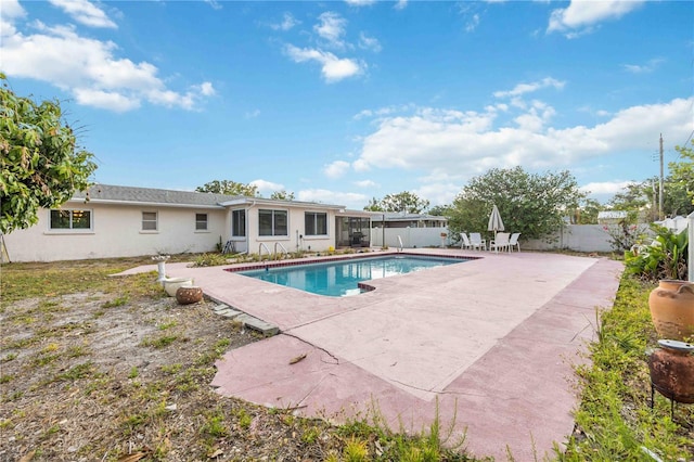 view of pool featuring a patio, a fenced backyard, and a sunroom