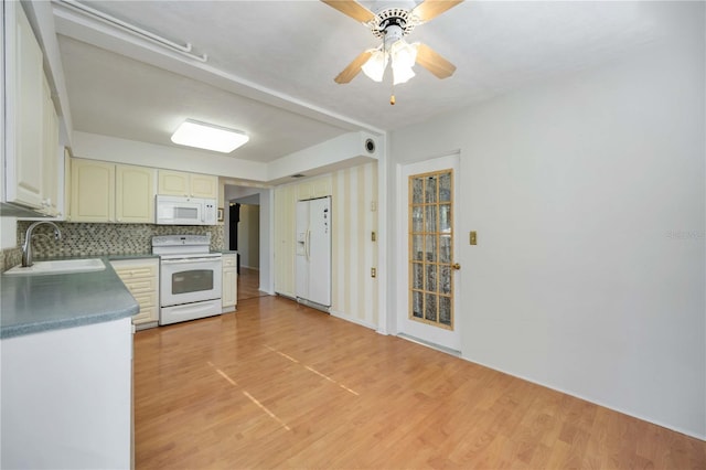 kitchen featuring white appliances, a sink, light wood-type flooring, ceiling fan, and tasteful backsplash