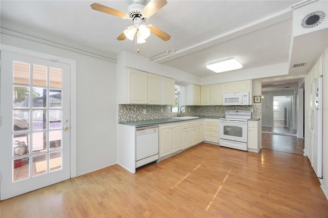 kitchen featuring backsplash, white appliances, visible vents, and a sink