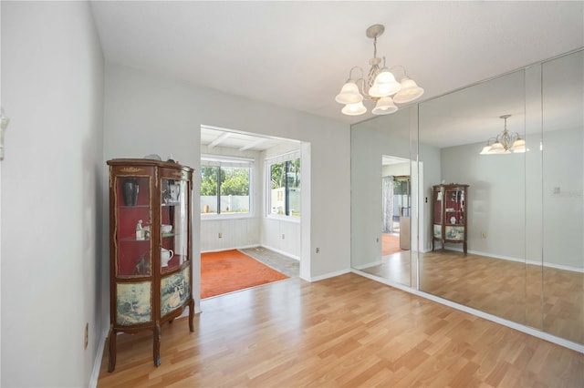 dining room featuring a chandelier, light wood-style flooring, and baseboards