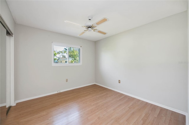 unfurnished bedroom featuring a closet, light wood-style floors, baseboards, and a ceiling fan