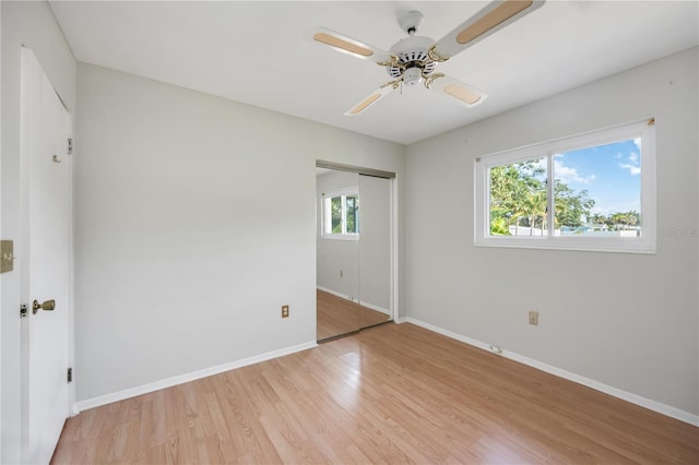 unfurnished bedroom featuring baseboards, light wood-style floors, a closet, and a ceiling fan