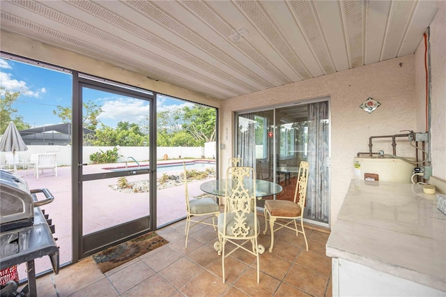 sunroom featuring water heater and outdoor dining area